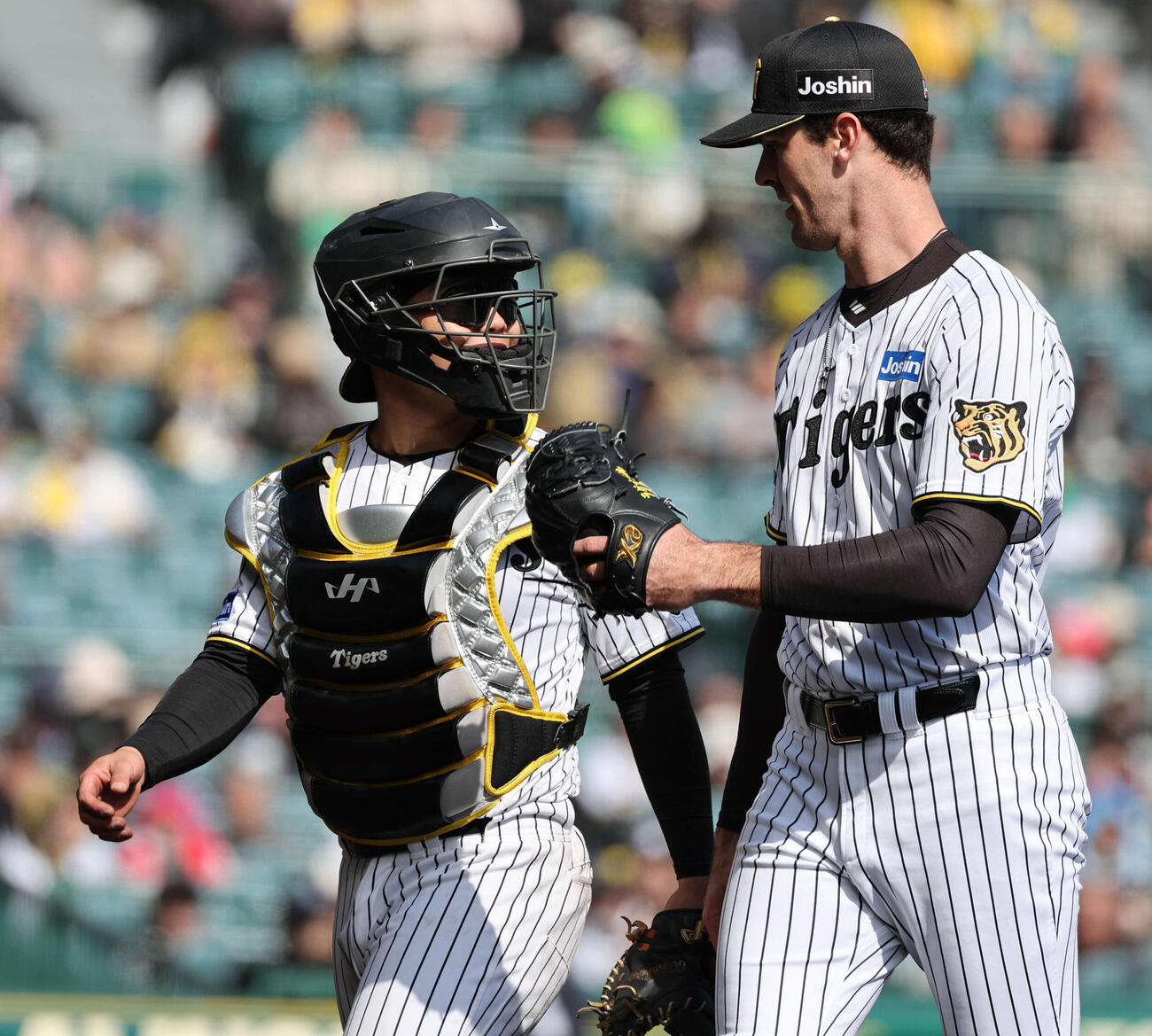 阪神対西武　4回を投げ終えた先発のラグズデール（右）と話しながらベンチに戻る嶋村（撮影・西尾就之）