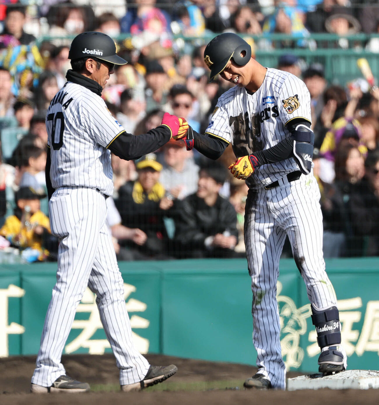 阪神対西武　7回裏阪神1死二、三塁、岡城は右中間に適時三塁打を放ち田中コーチとタッチをかわす（撮影・西尾就之）