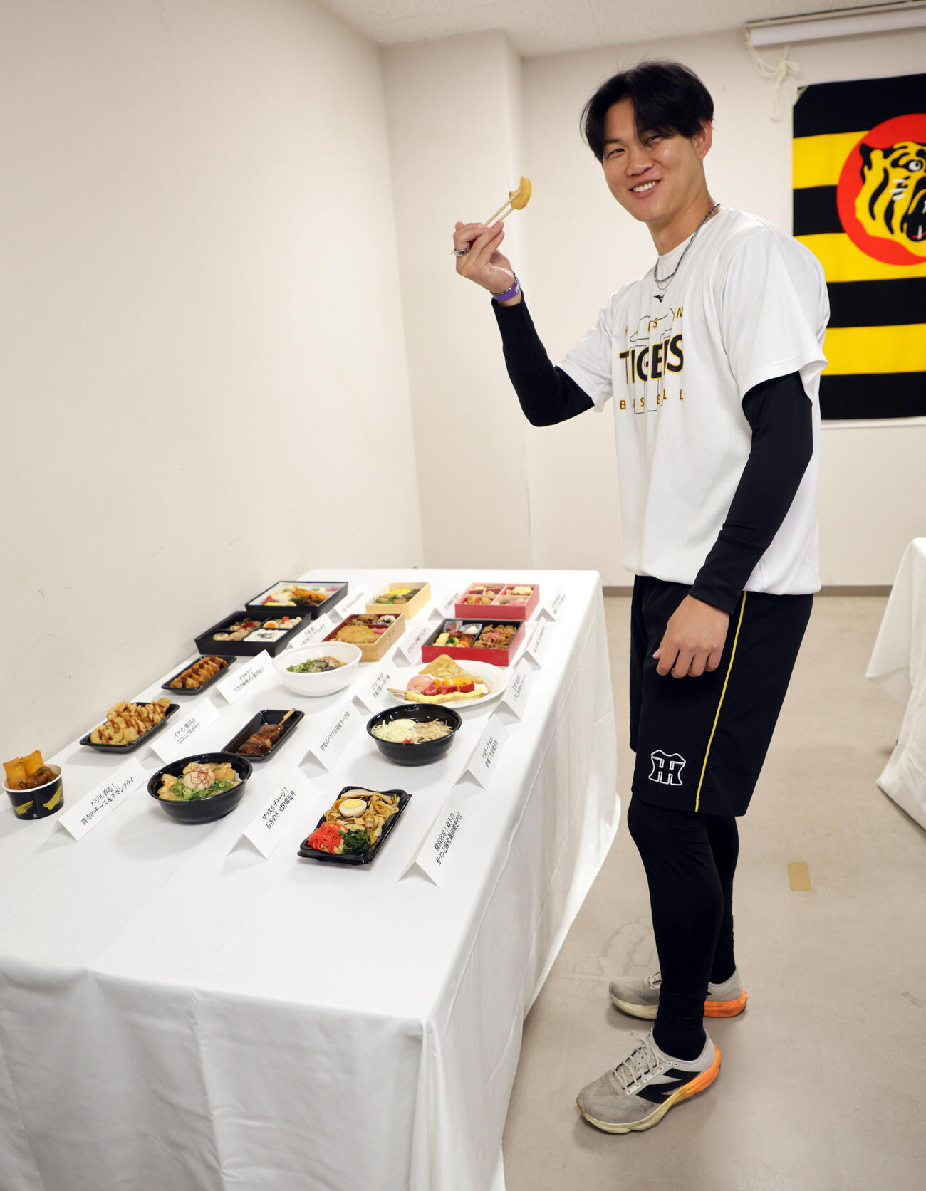 発表された監督・選手コラボグルメを試食する阪神及川（撮影・宮崎幸一）