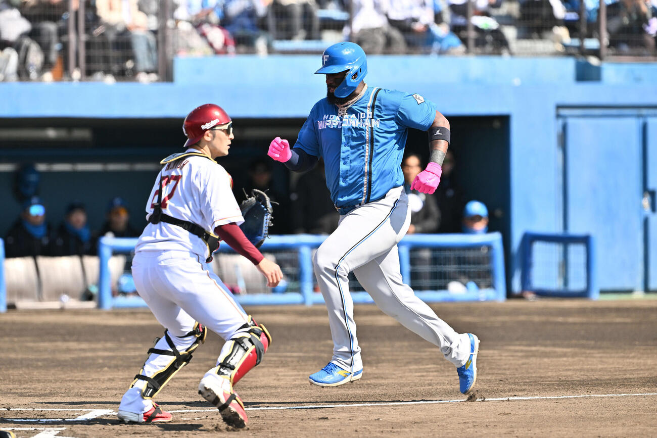 楽天対日本ハム　1回表日本ハム1死満塁、西川の犠飛で生還するレイエス（右）。捕手伊藤光（撮影・滝沢徹郎）