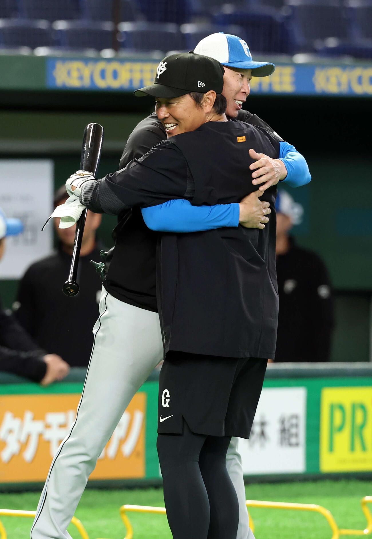 巨人対日本ハム　試合前、日本ハム森本外野守備コーチ（奥）と抱擁する巨人長野（撮影・浅見桂子）