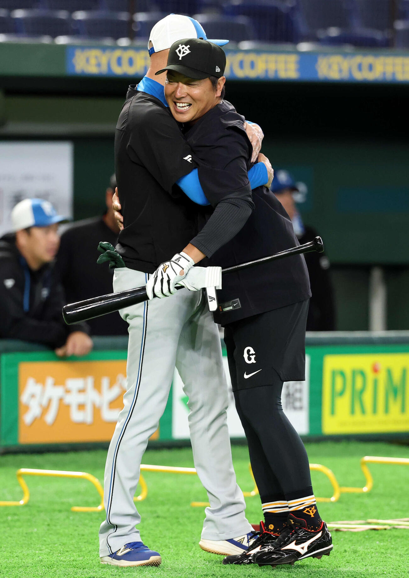 巨人対日本ハム　試合前、日本ハム森本外野守備コーチ（奥）と抱擁する巨人長野（撮影・浅見桂子）