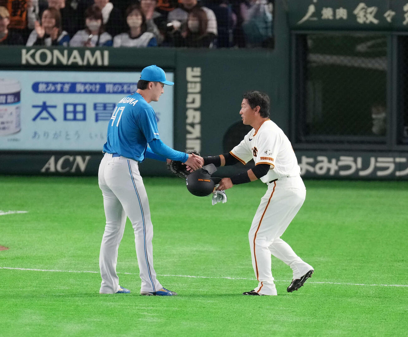 巨人対日本ハム　8回を終え握手を交わす日本ハム柳川（左）と巨人長野（撮影・増田悦実）