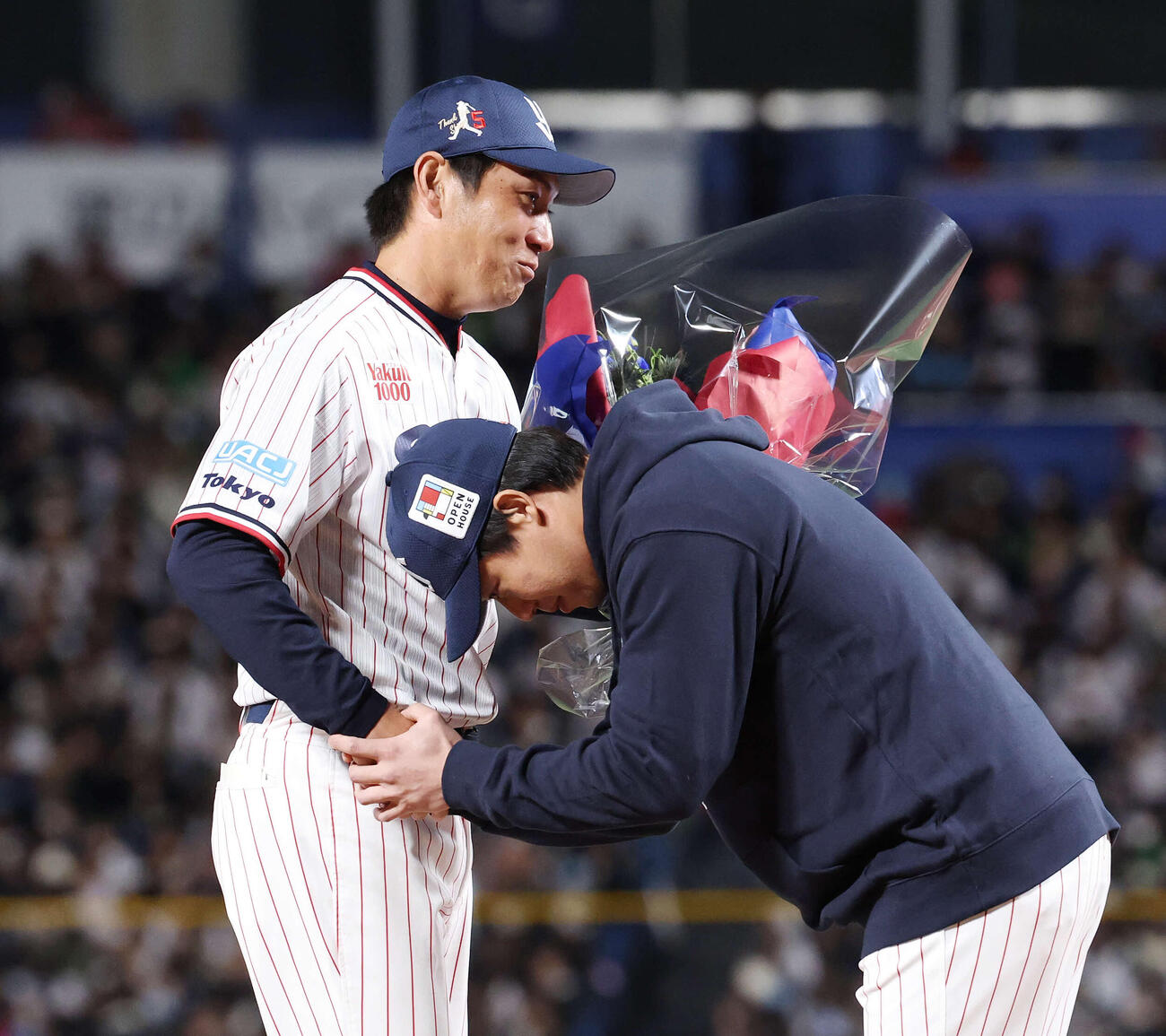 ヤクルト対オリックス　引退セレモニーでヤクルト山田（手前）から花束を受け取り握手を交わす川端（撮影・宮地輝）