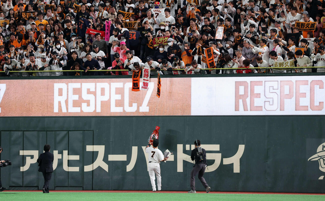 巨人対日本ハム　引退試合後、場内1周で右翼スタンドのファンからの花束を受け取る巨人長野（撮影・浅見桂子）