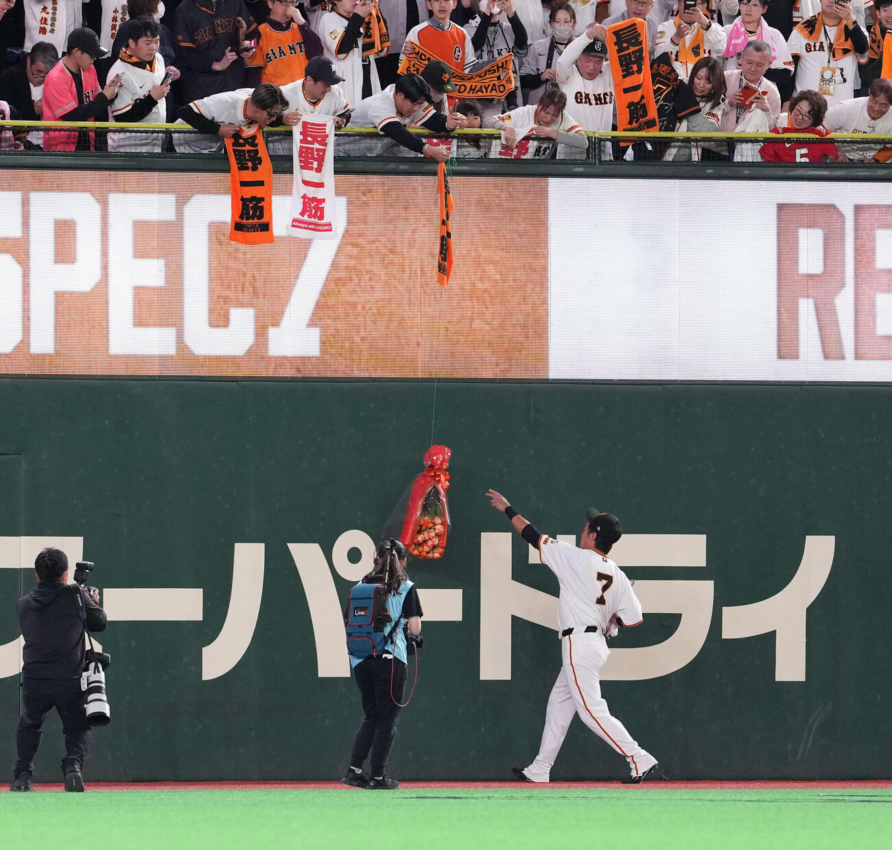 巨人対日本ハム　スタンドからのプレゼントを受け取る長野（撮影・井上学）