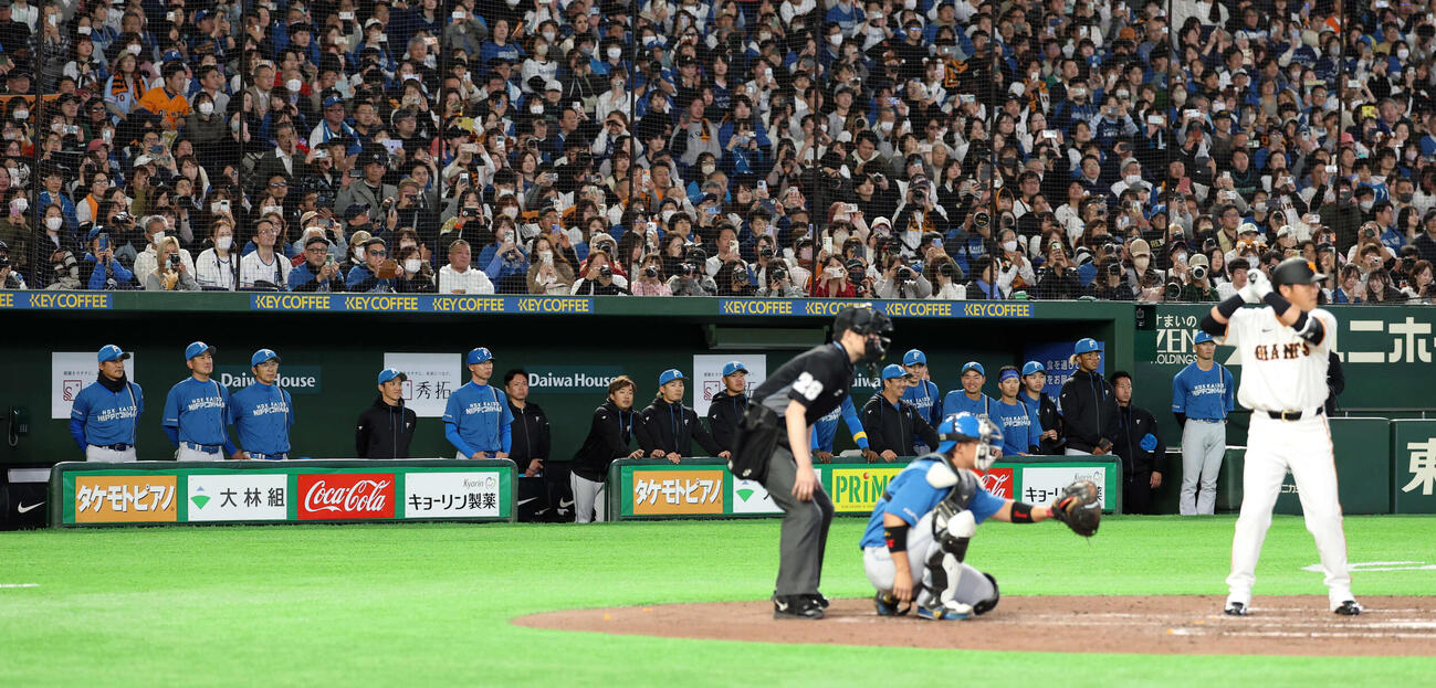 巨人対日本ハム　8回裏巨人2死、代打長野（手前）がコールされると、ジャンパーもマスクも脱ぎ整列して見つめる新庄監督（左）ら日本ハムの選手たち（撮影・浅見桂子）