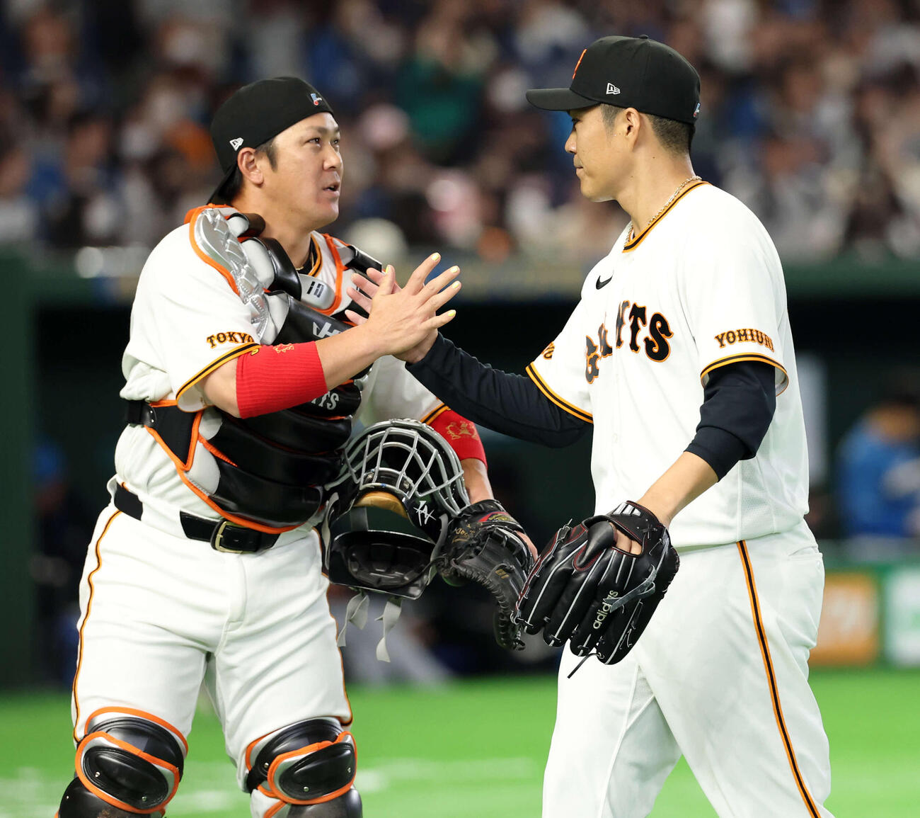 巨人対日本ハム　1回表日本ハムの攻撃を抑えた則本（右）は甲斐とハイタッチ（撮影・浅見桂子）