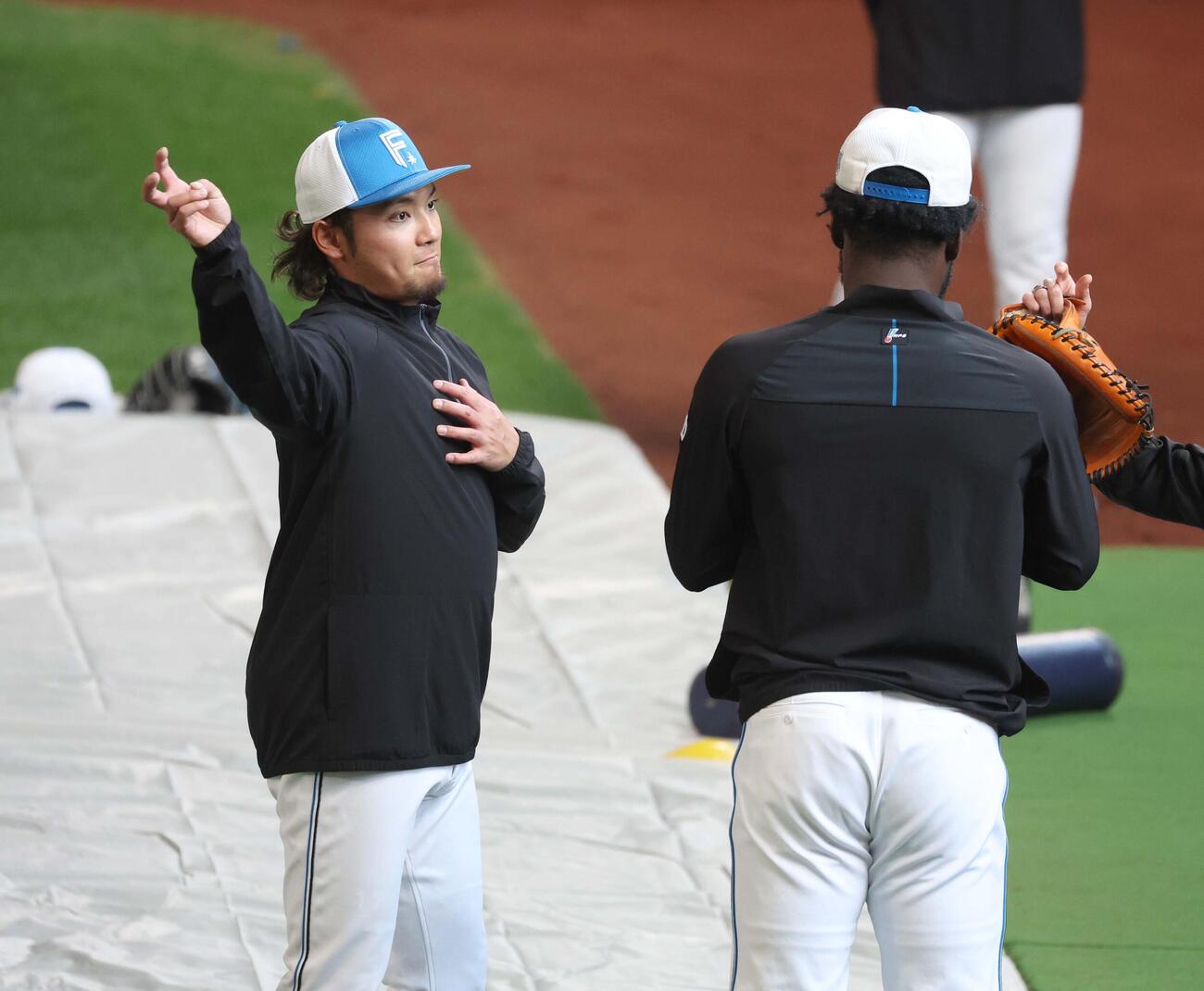 日本ハム対DeNA　ラオ（右）と投球について話す伊藤（撮影・黒川智章）
