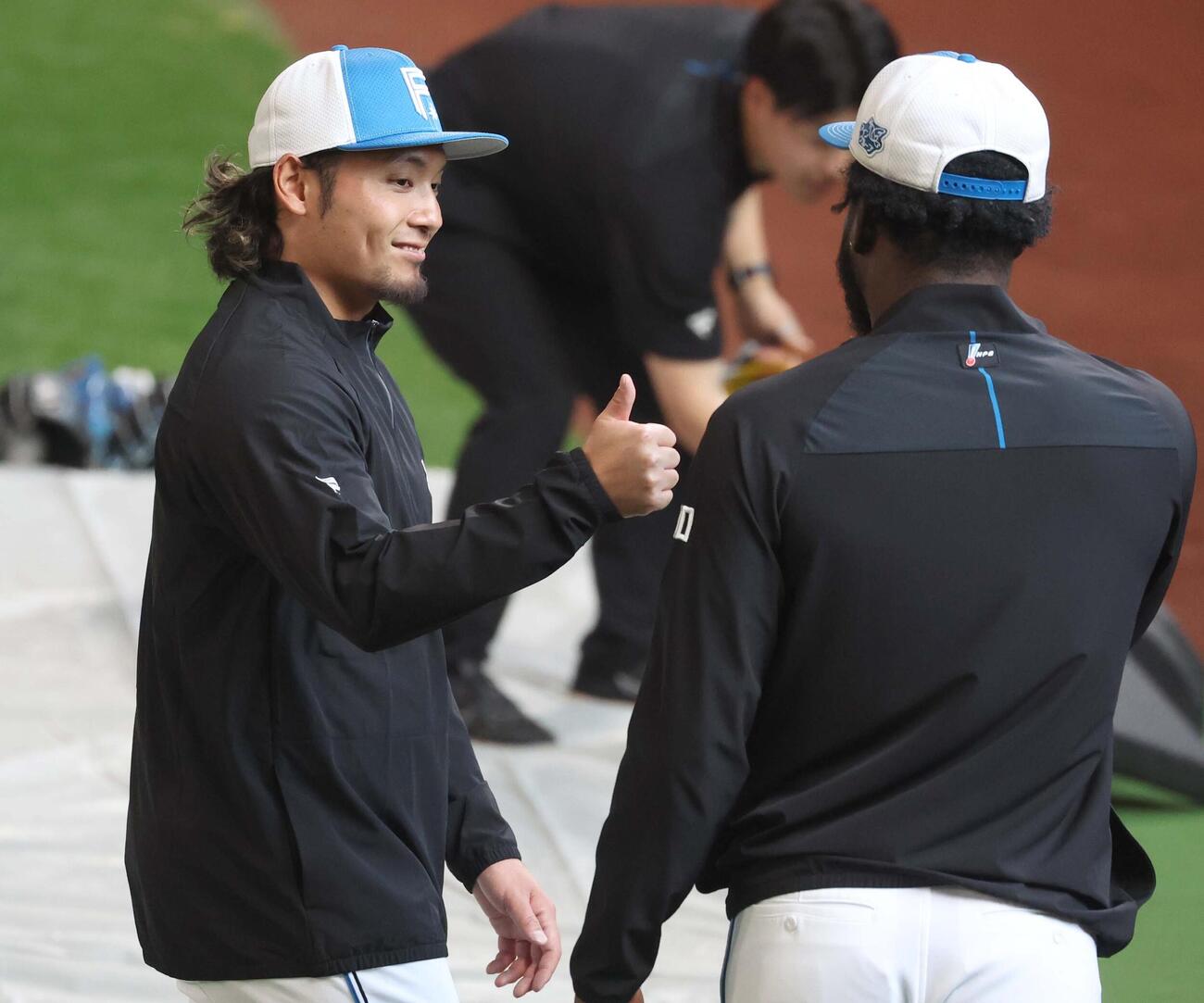 日本ハム対DeNA　ラオ（右）と投球について話す伊藤（撮影・黒川智章）