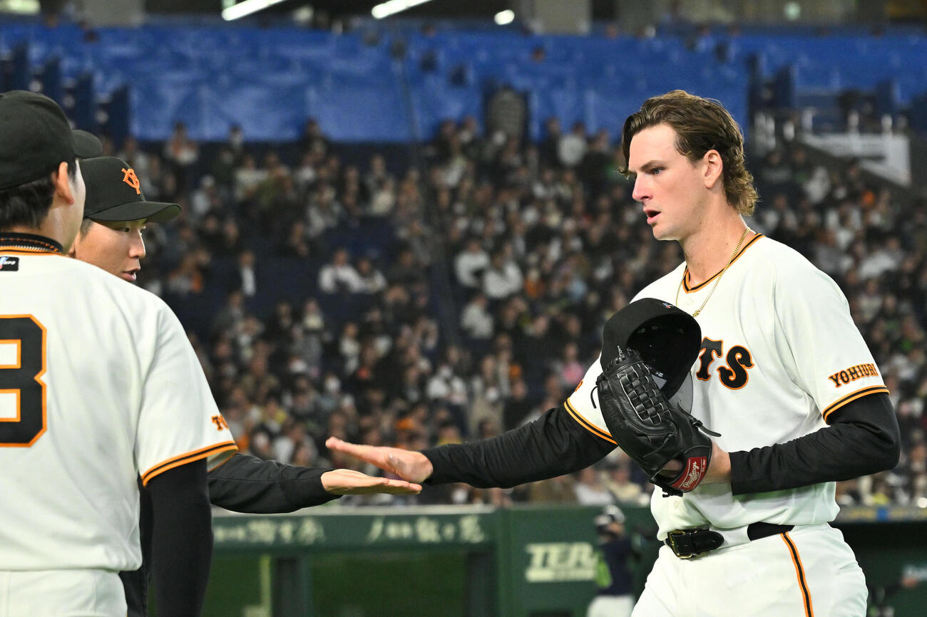 巨人対ヤクルト　9回表途中で降板した巨人2番手のフウィットリー（右）は戸郷とタッチを交わす（撮影・滝沢徹郎）