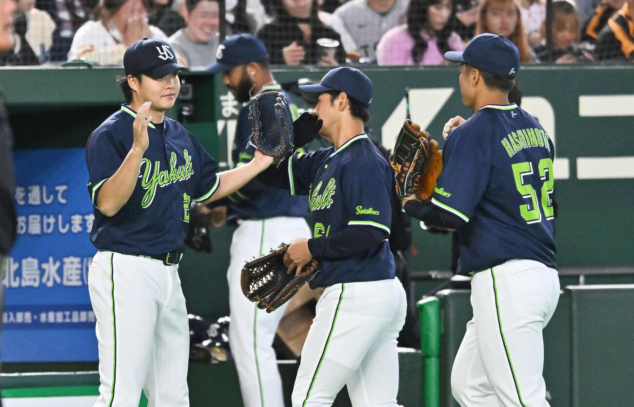 巨人対ヤクルト　3回裏巨人2死満塁、キャベッジを三邪飛に打ち取った松本健（左）はナインとタッチを交わす（撮影・滝沢徹郎）
