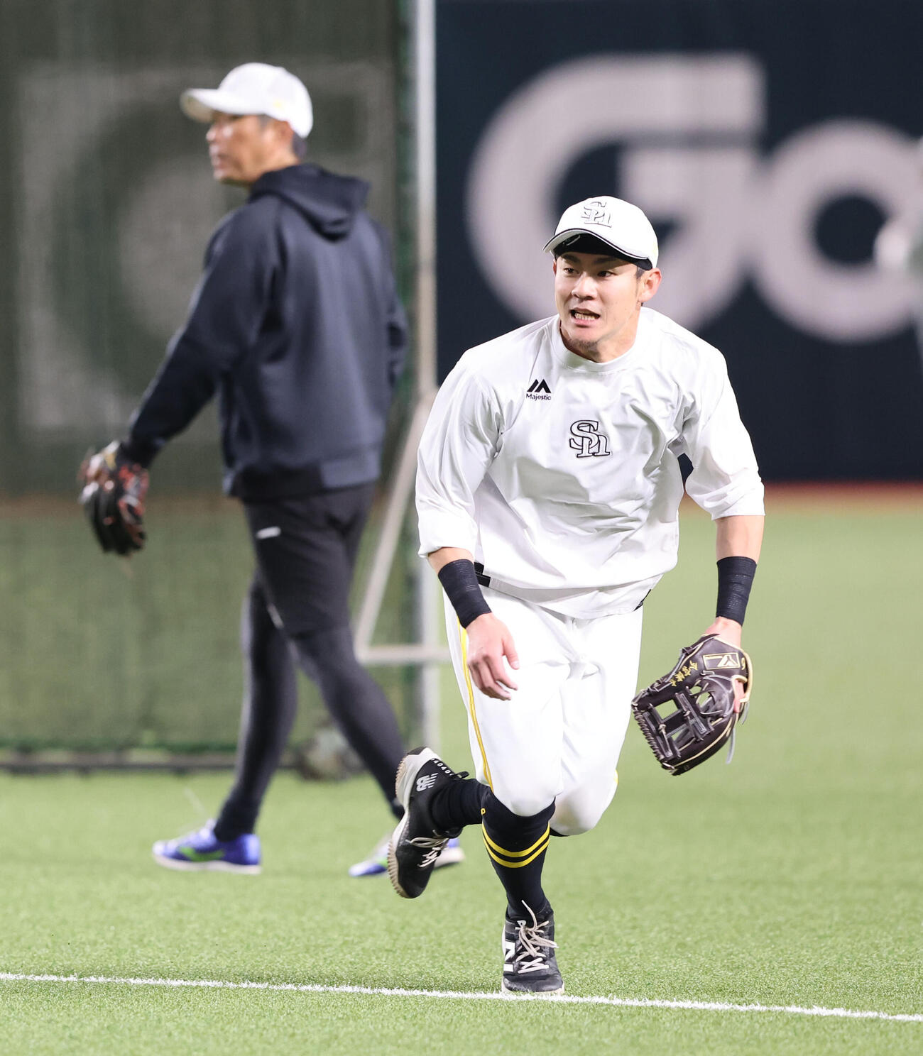 守備練習で軽快な動きを見せる牧原大、後方は小久保監督（撮影・梅根麻紀）
