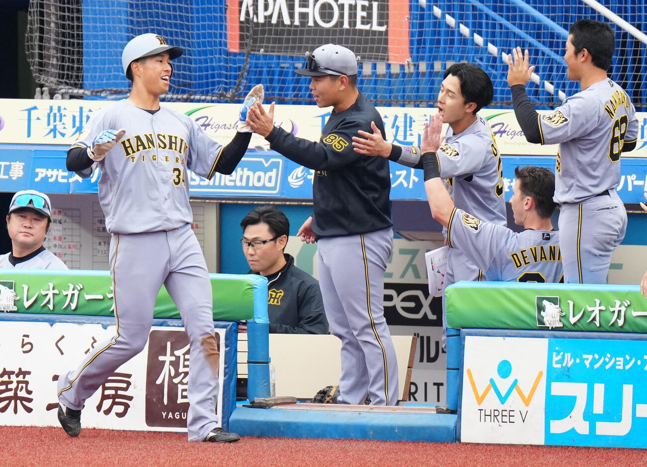 ロッテ対阪神　6回表阪神1死二塁、木浪の適時二塁打で生還しタッチを交わす岡城（手前左）（撮影・江口和貴）