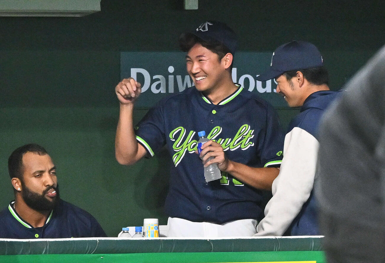 巨人対ヤクルト　5回裏を投げ終えたヤクルト先発の奥川（中央）はベンチで笑顔を見せる（撮影・滝沢徹郎）