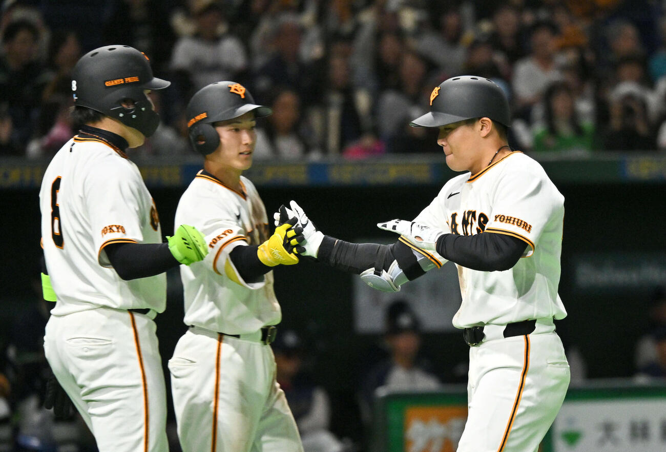 巨人対ヤクルト　7回裏巨人1死二塁、2点本塁打を放った佐々木（右）は生還しチームメートとタッチをかわす（撮影・滝沢徹郎）