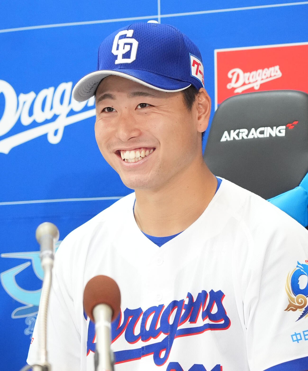 支配下登録され明るい表情で会見する牧野（撮影・森本幸一）