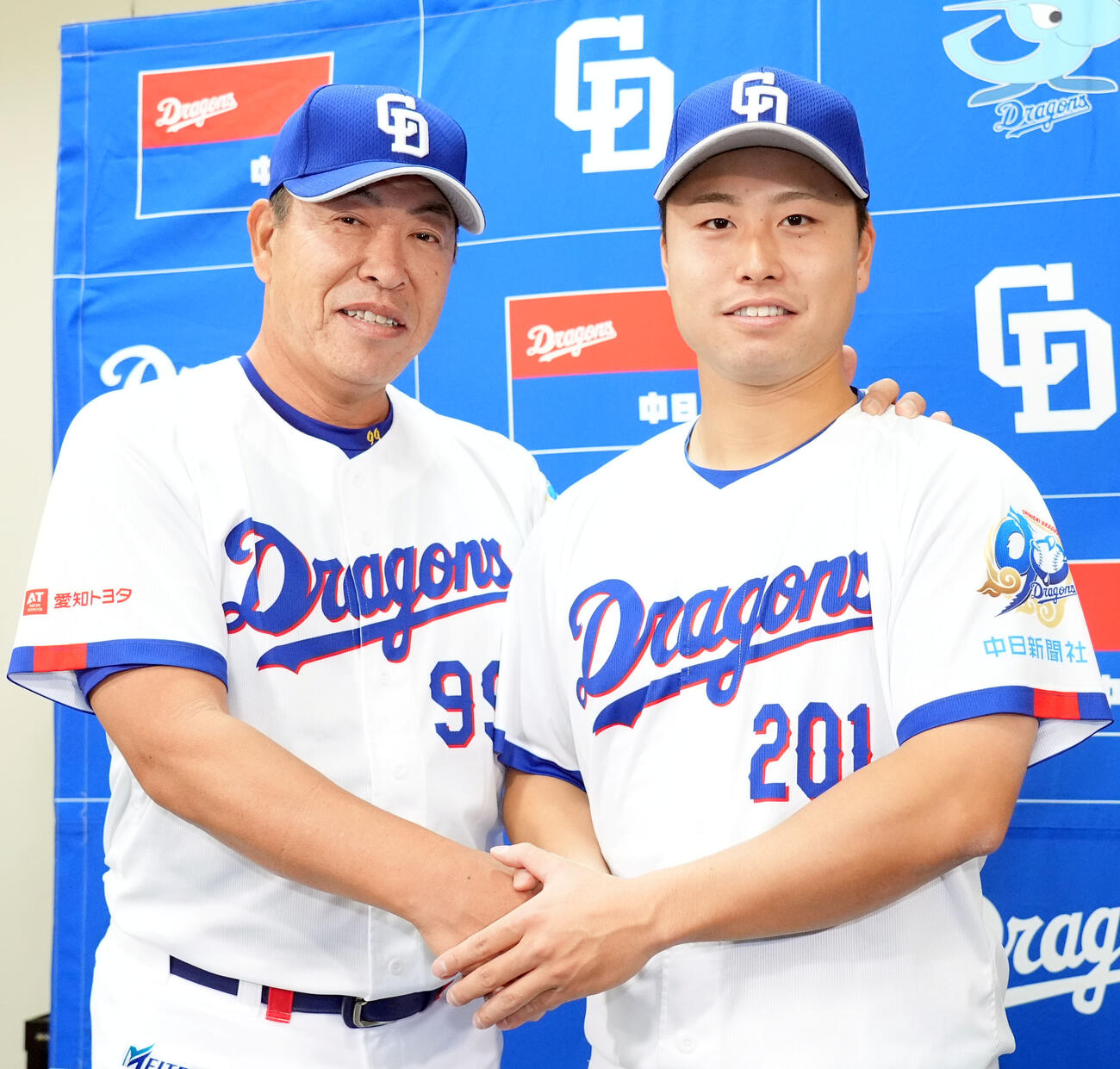 支配下登録された牧野（右）は会見後に井上監督と握手を交わす（撮影・森本幸一）