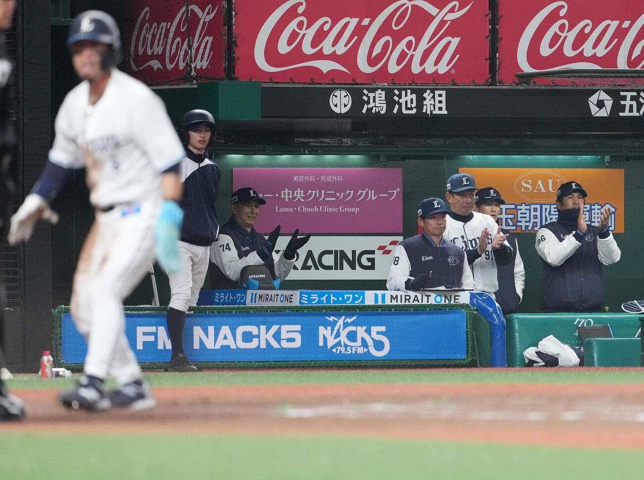 西武対DeNA 7回裏西武2死二、三塁、代打山村の内野安打と遊撃手石上の悪送球で二塁走者外崎が生還し、手をたたく西口監督（左後方）（撮影・鈴木みどり）