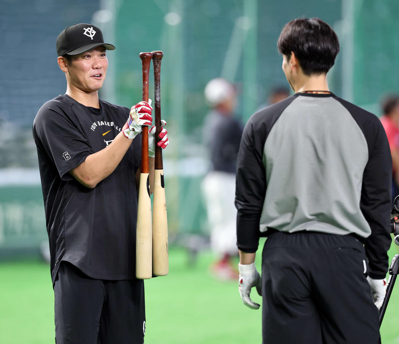 巨人対楽天　試合前、巨人坂本勇（左）は2本のバットのグリップを比べて驚いたような表情を見せる。右は松本（撮影・浅見桂子）