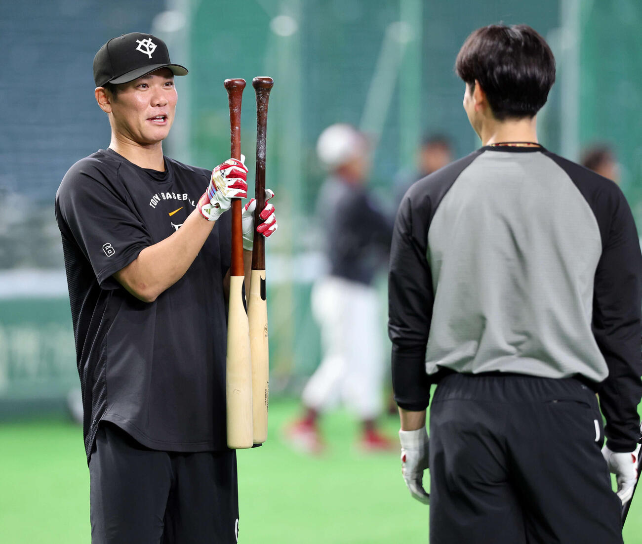 巨人対楽天　試合前、巨人坂本勇（左）は2本のバットのグリップを比べて驚いたような表情を見せる。右は松本（撮影・浅見桂子）