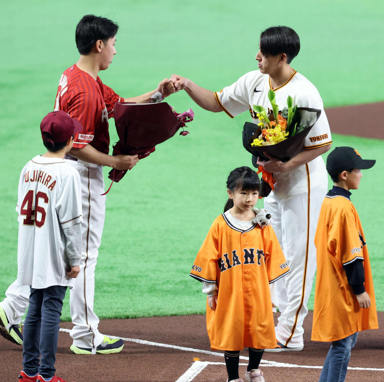 巨人対楽天　試合前、WBC出場者に子供ファンから花束贈呈され、グータッチする楽天藤平（左）と巨人大勢（撮影・浅見桂子）