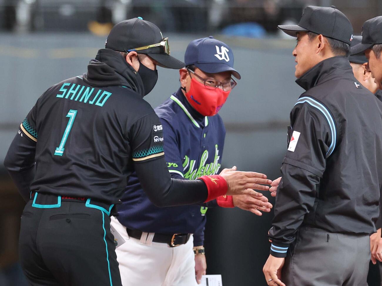日本ハム対ヤクルト　友人からプレゼントされた赤いマスクつけてメンバー表交換する池山監督と新庄監督（撮影・黒川智章）