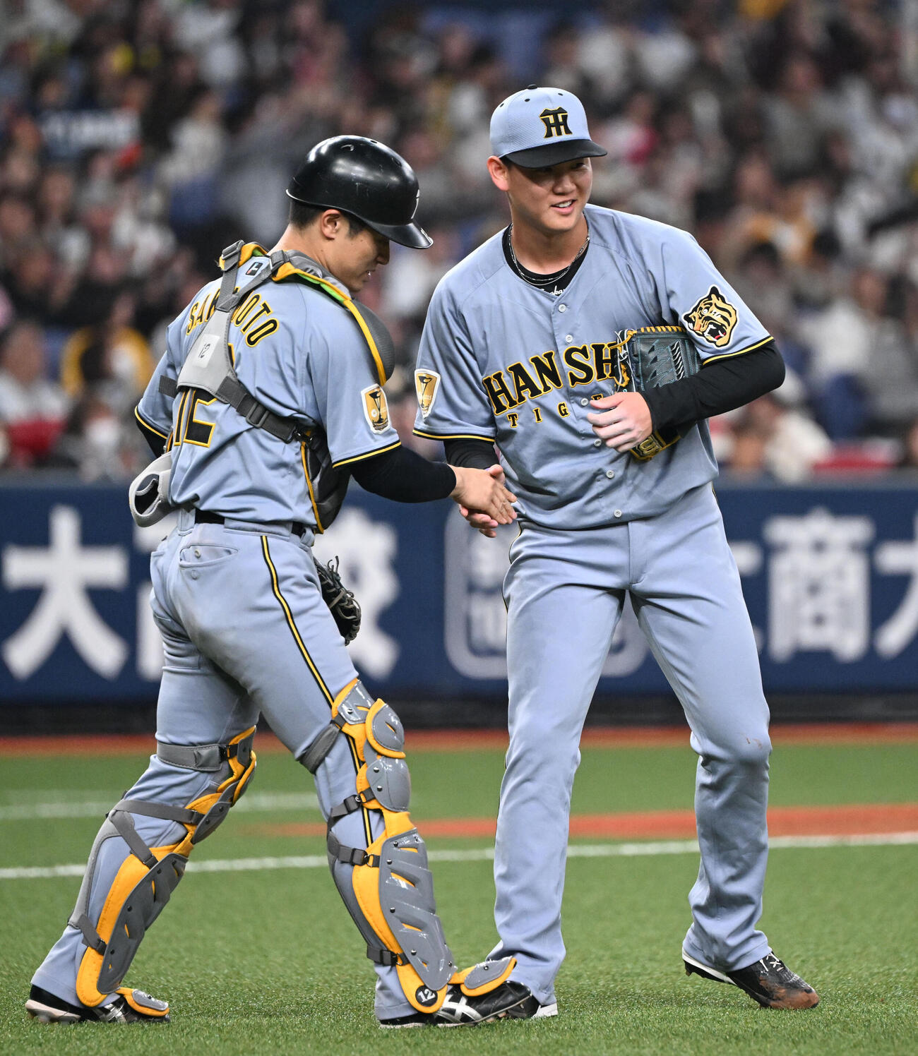 オリックス対阪神　9回を締めた阪神及川（右）と捕手坂本は握手を交わす（撮影・和賀正仁）