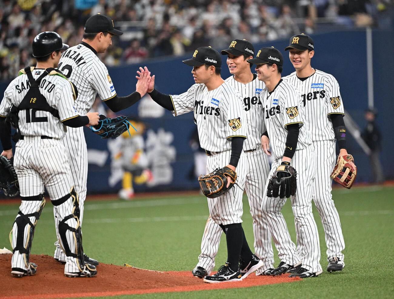 阪神対オリックス　オリックスに勝利しタッチを交わす阪神岩崎（左から2人目）らナイン（撮影・和賀正仁）