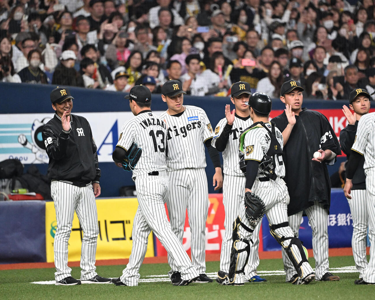 阪神対オリックス　9回を締めた阪神岩崎（左から2人目）を迎える藤川監督（撮影・和賀正仁）