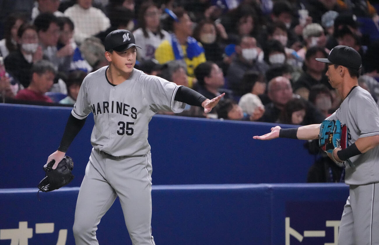 中日対ロッテ　1回終了、田中（左）はナインとタッチを交わしベンチへ戻る（撮影・森本幸一）