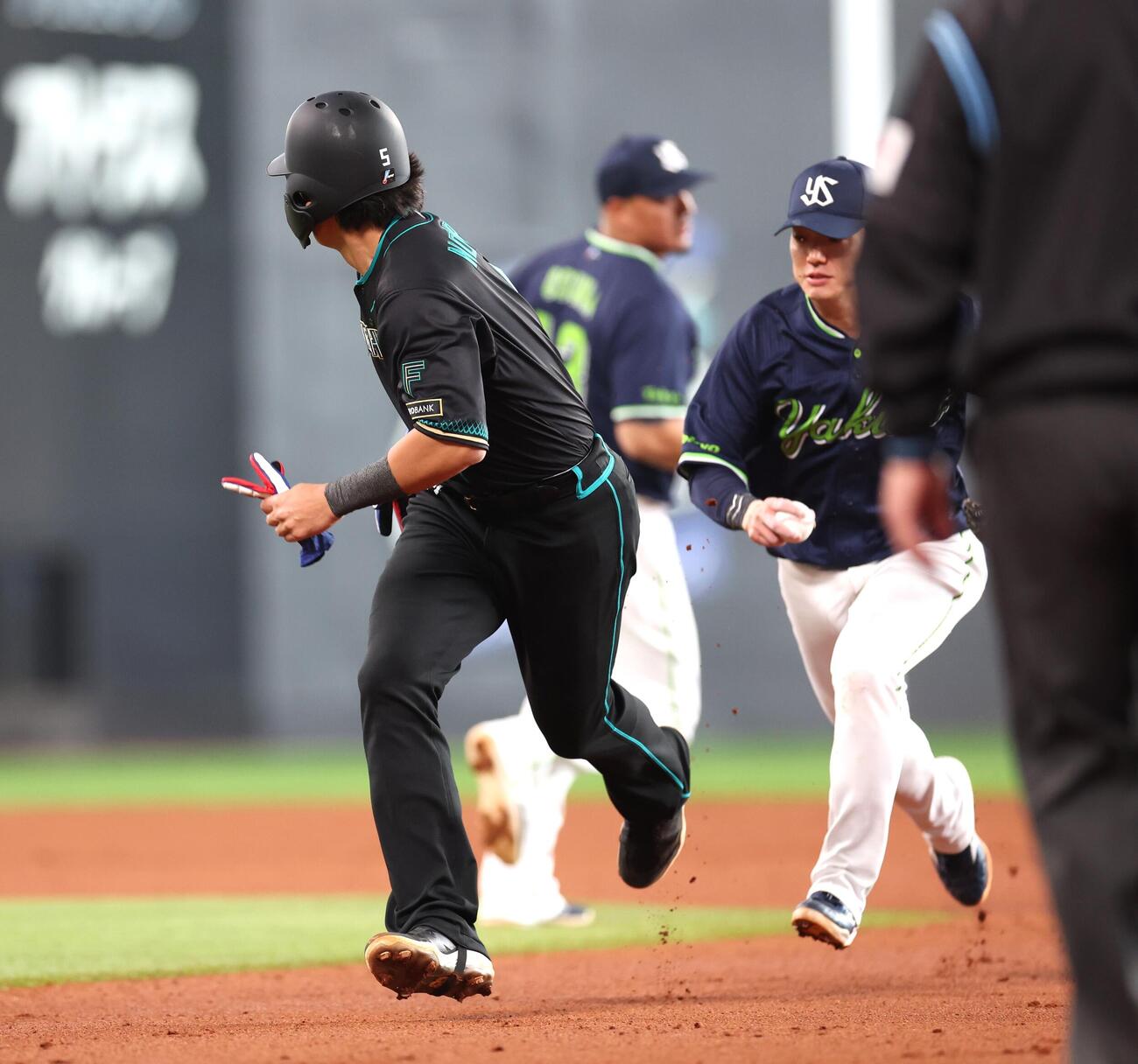 日本ハム対ヤクルト　1回裏日本ハム2死一、三塁、一塁走者野村が一二塁間で挟まれる間に、三塁走者郡司が本塁に生還（撮影・黒川智章）