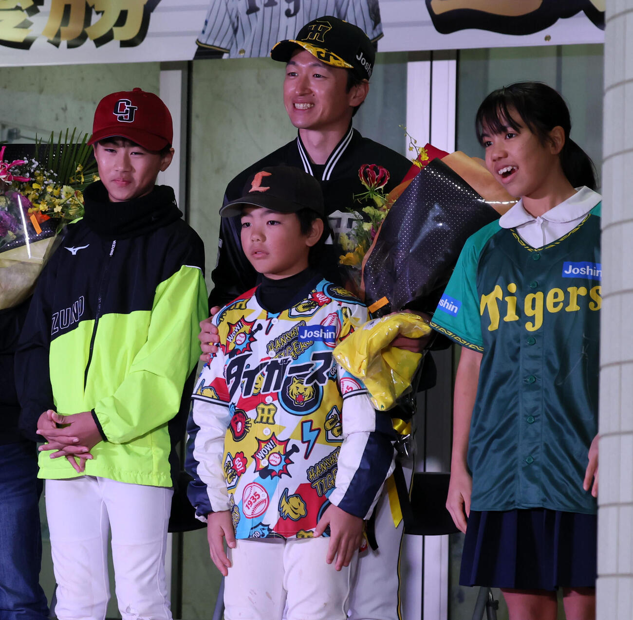 26年1月、和泊町の優勝記念イベントで子どもたちと記念写真に納まる阪神近本