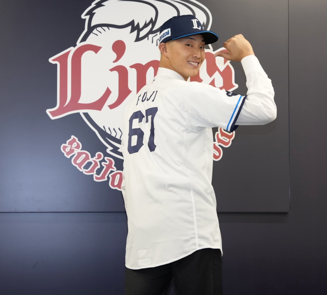 支配下登録され笑顔で写真に納まる冨士（撮影・小島史椰）