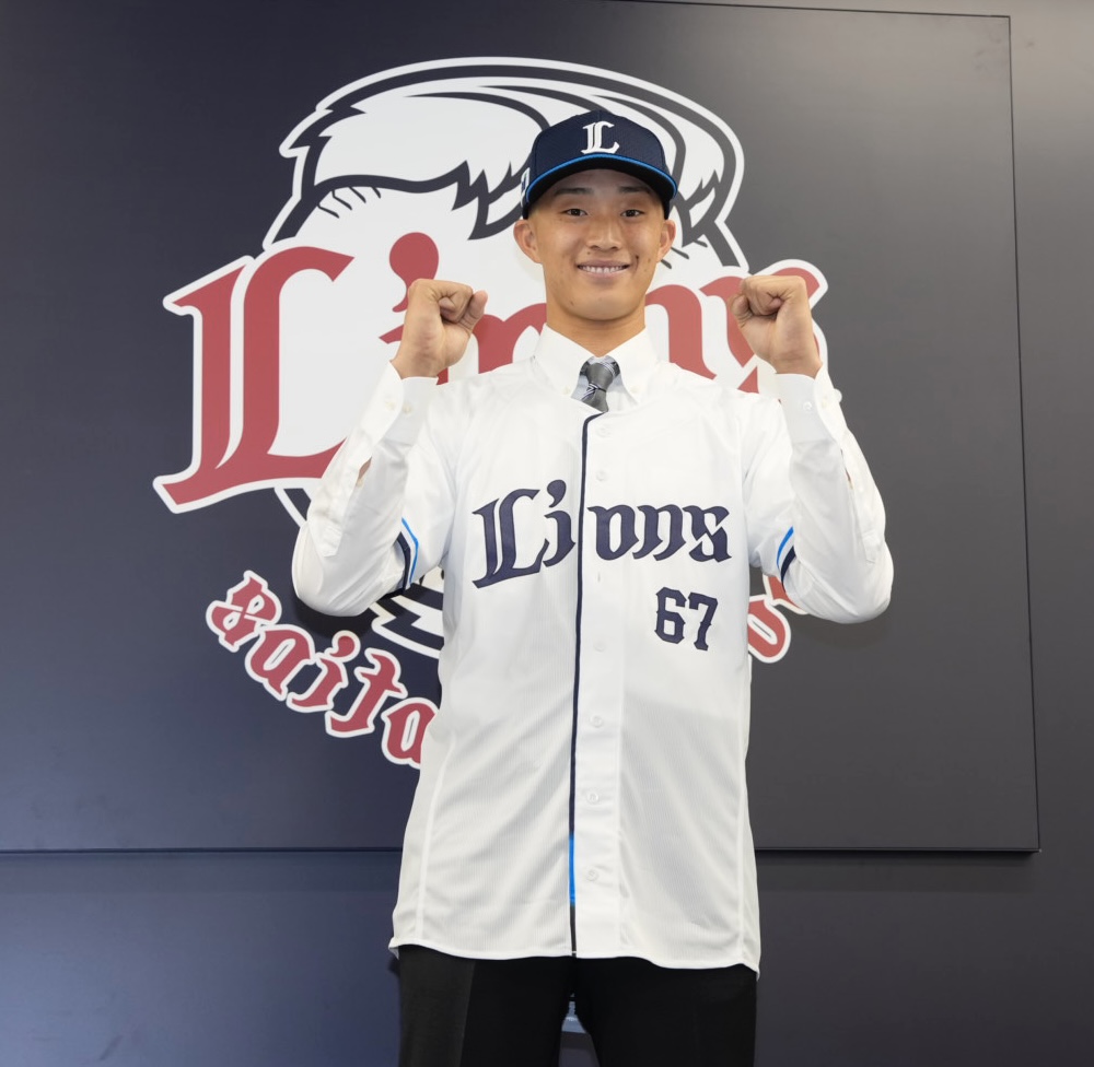 支配下登録され笑顔で写真に納まる冨士（撮影・小島史椰）