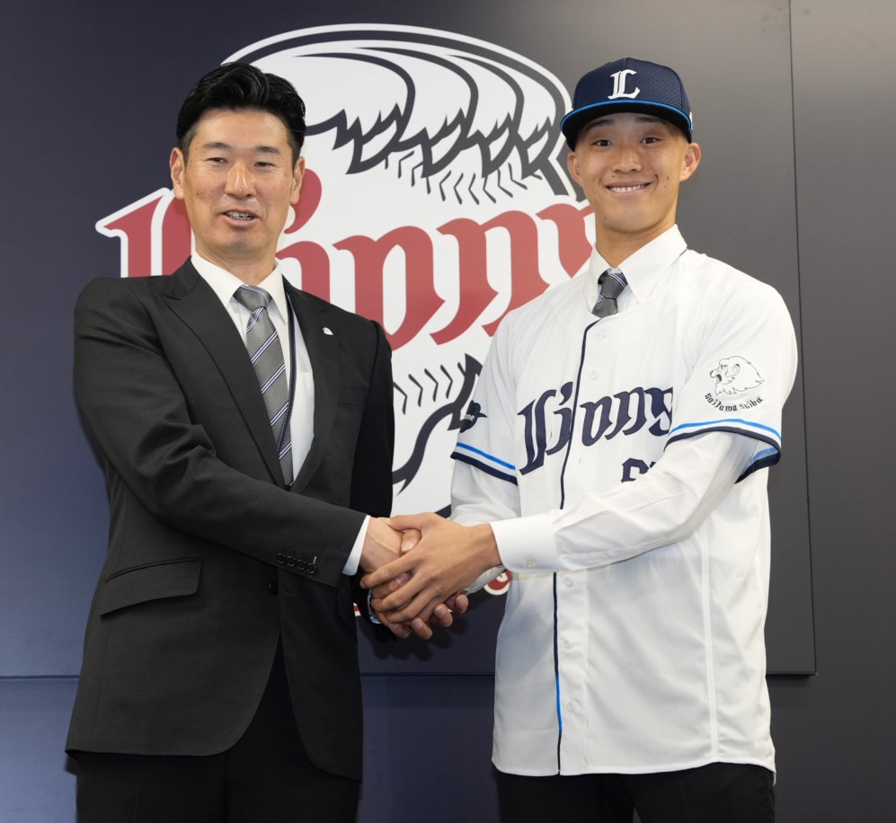 支配下登録され笑顔で写真に納まる冨士（右）と広池球団本部長（撮影・小島史椰）
