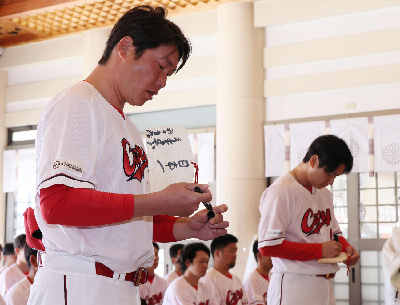 奉納する絵馬に「日本一」と記す広島新井監督（左）と島内選手会長（撮影・加藤孝規）