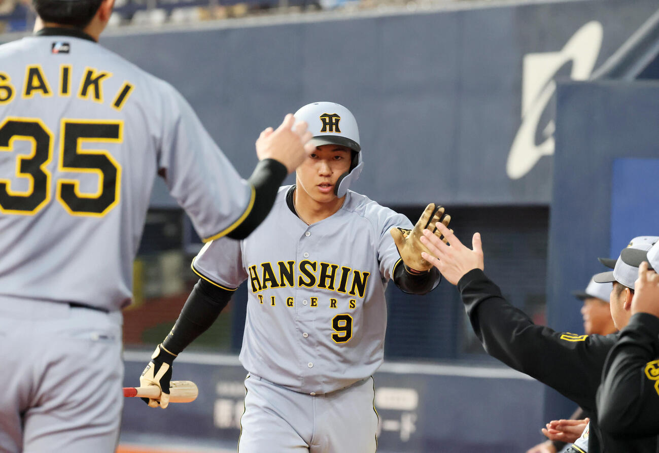 オリックス対阪神　3回表阪神1死二、三塁、戸井の中前適時打で生還しベンチのナインとタッチする三走立石（撮影・加藤哉）