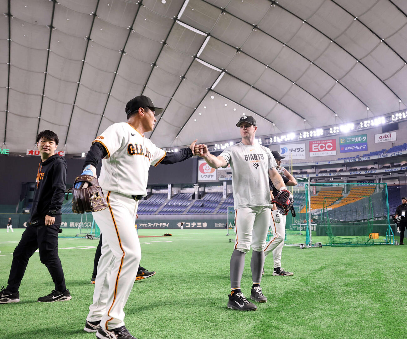 フリー打撃で右中間の大型ビジョン上に打ち込んだ巨人キャベッジ（右）は打撃投手とグータッチ（撮影・浅見桂子）