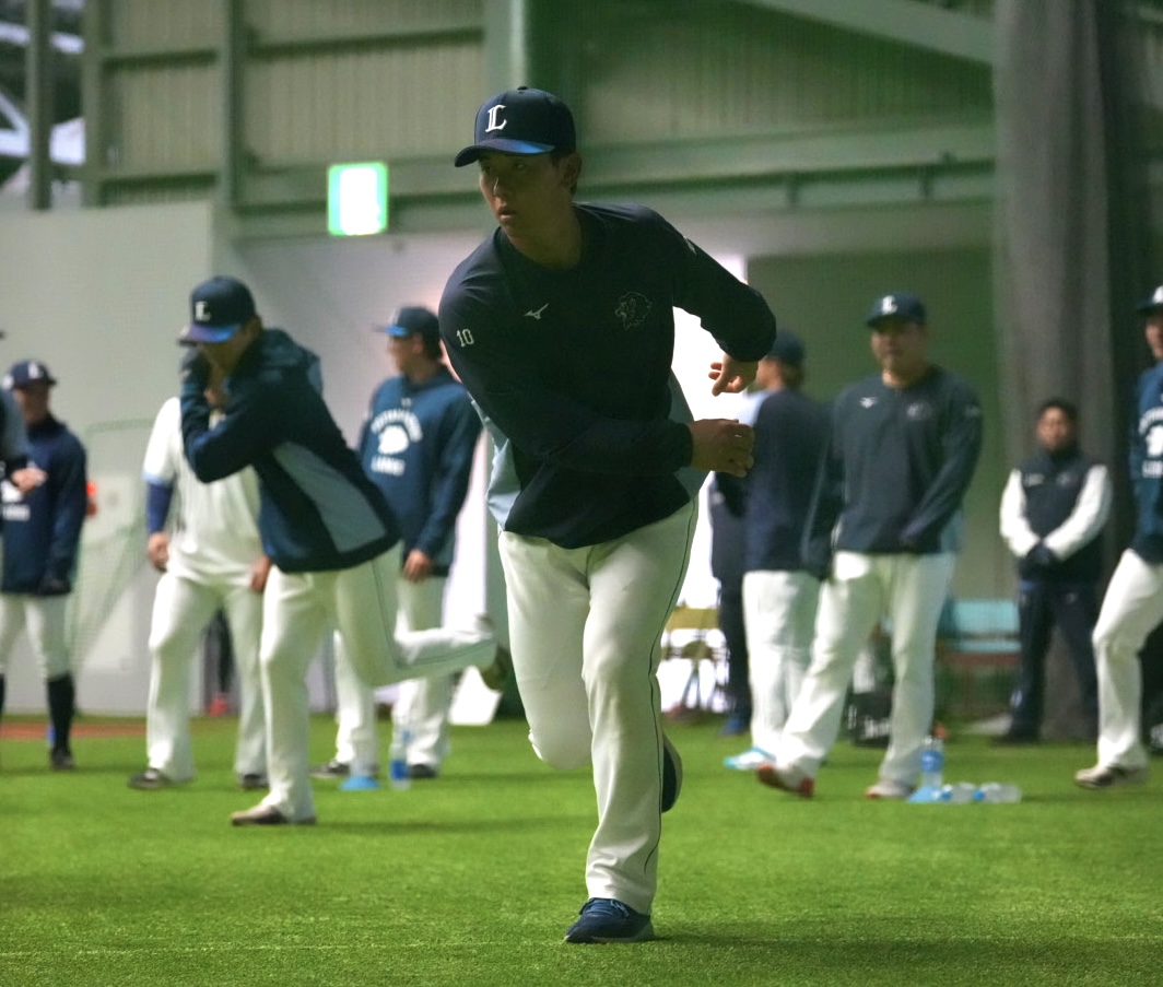 ウォーミングアップをする西武小島（撮影・小島史椰）