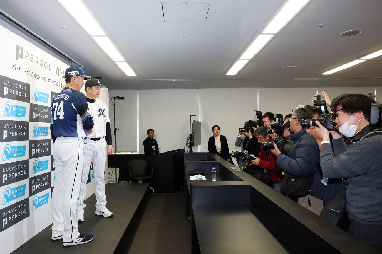 開幕前日記者会見で握手を交わす西武西口監督（左）とロッテのサブロー監督（撮影・宮地輝）