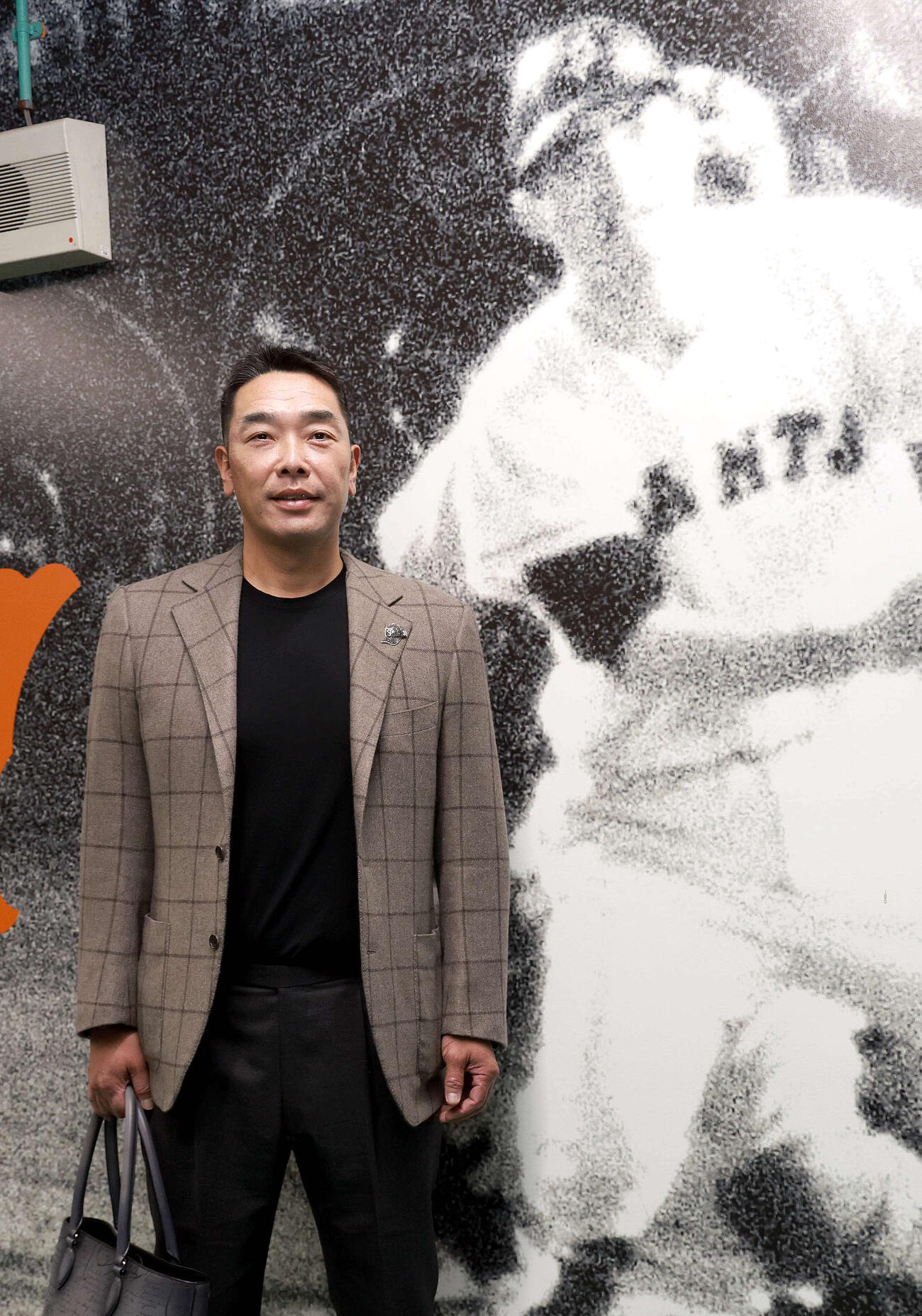 阿部監督は形見の品を身に付け、東京ドーム通路の長嶋氏との写真の前に立つ（読売巨人軍提供）