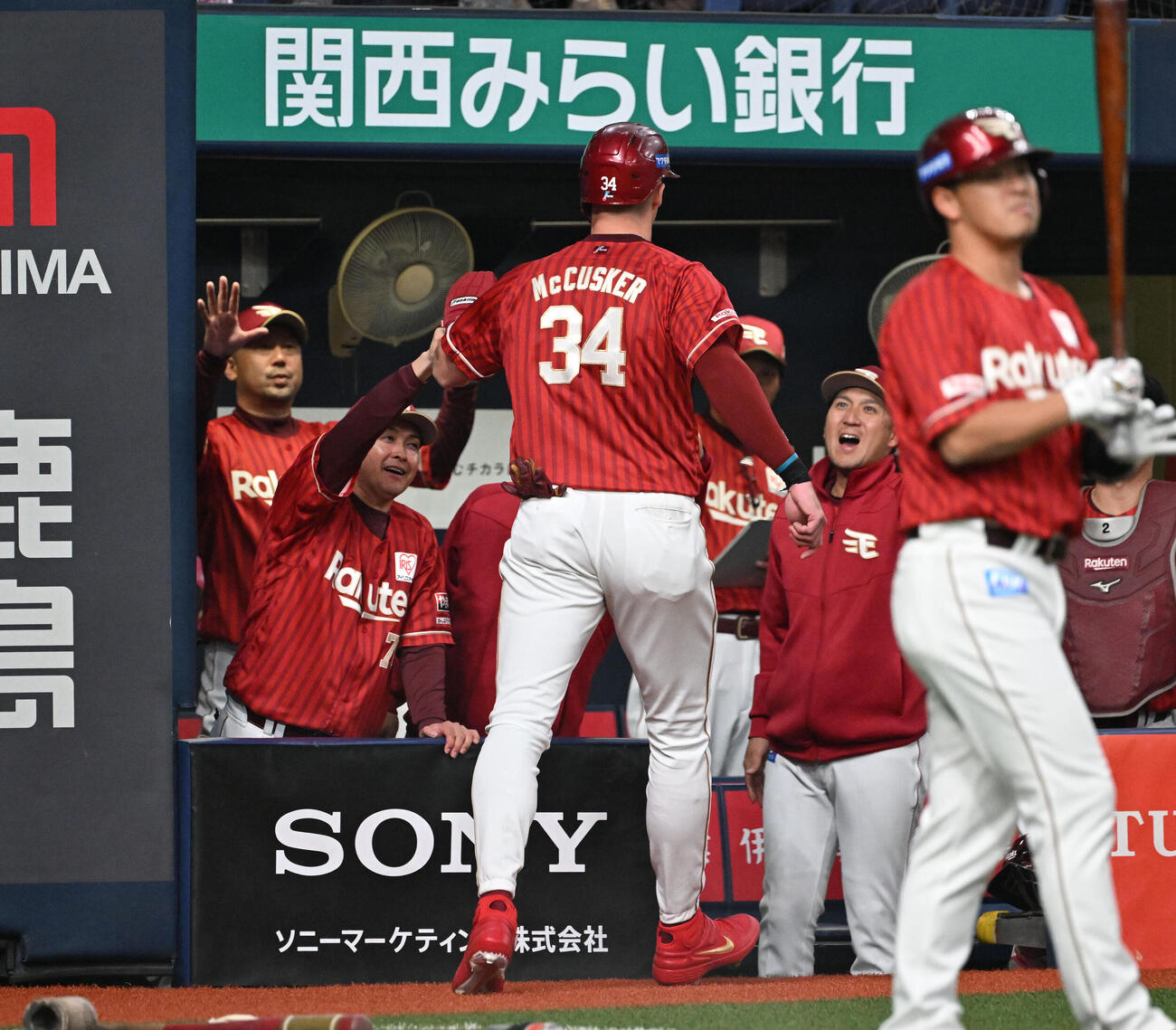 オリックス対楽天　2回表楽天2死二塁、浅村の適時打で生還したマッカスカーを迎える三木監督（左奥）（撮影・和賀正仁）