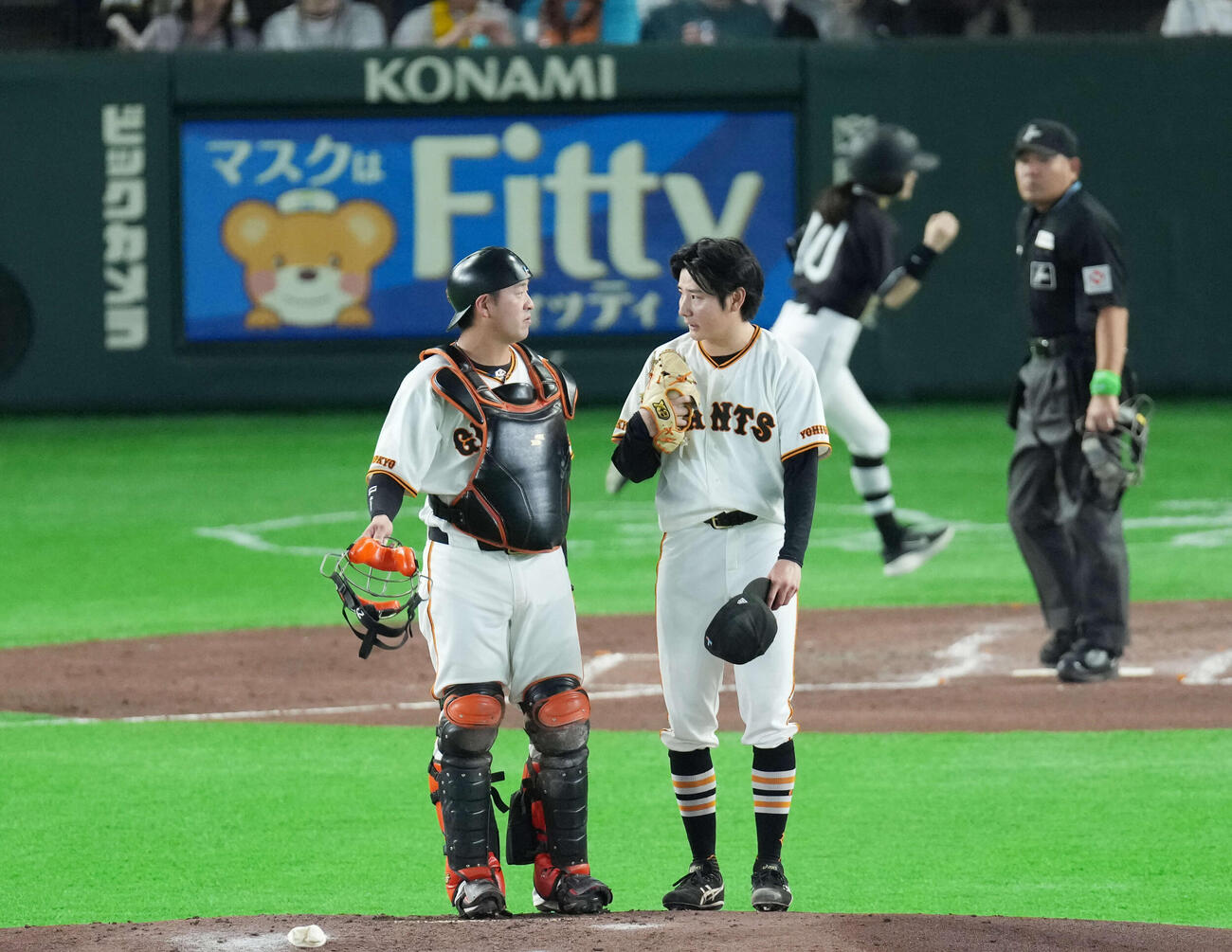 巨人対阪神　4回表阪神無死一、二塁、走者を抱え話をする岸田（左）と竹丸（撮影・増田悦実）