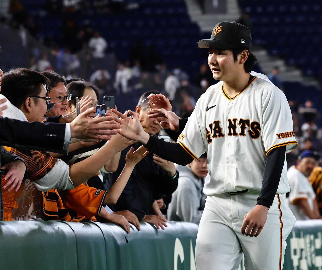 巨人対阪神　プロ初勝利をあげた竹丸（右）と先頭打者本塁打を放ったキャベッジはファンとタッチする（撮影・上田博志）