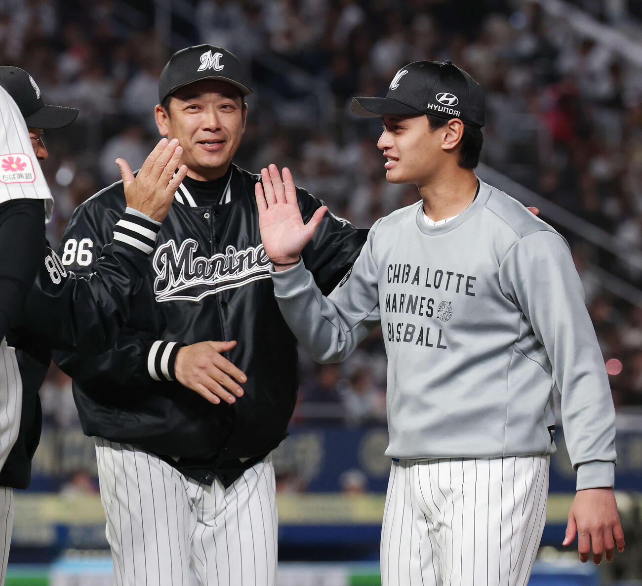 ロッテ対西武　初勝利を挙げタッチを交わすロッテのサブロー監督（左）と毛利（撮影・宮地輝）