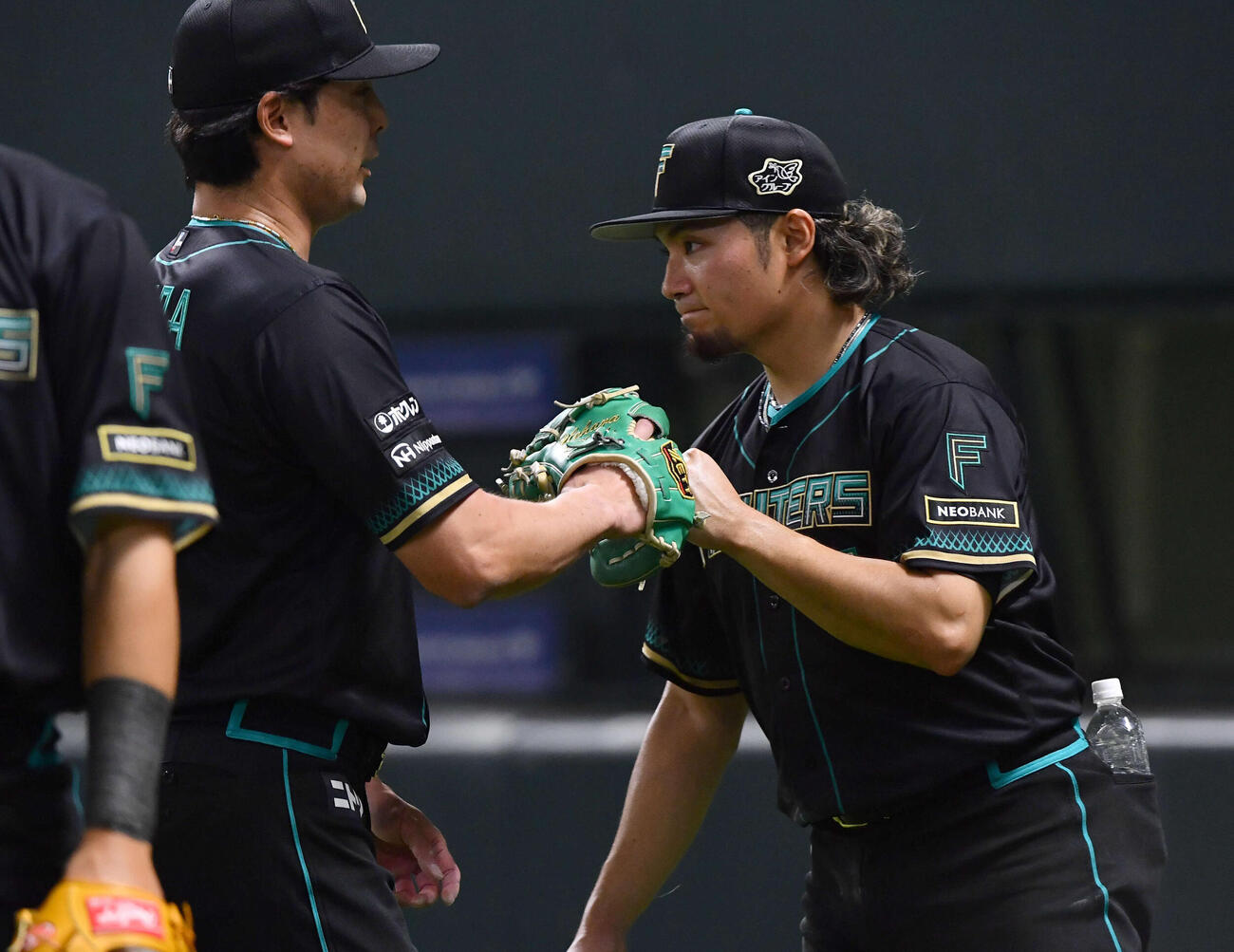 ソフトバンク対日本ハム　6回裏終了後、降板後の後続を抑えた上原（左）を迎える伊藤（撮影・岩下翔太）