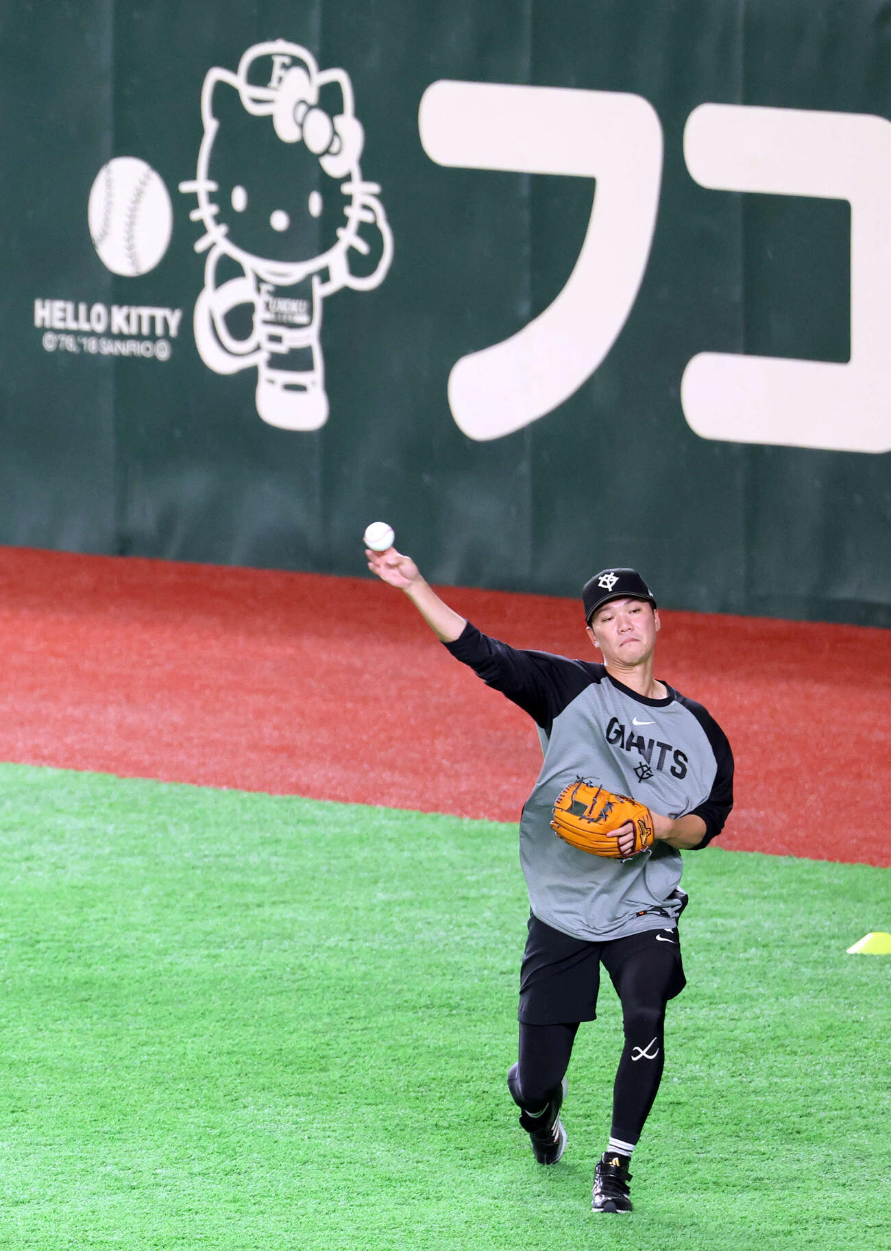 巨人対阪神　キティーちゃんの看板を背にキャッチボールする巨人坂本勇（撮影・浅見桂子）
