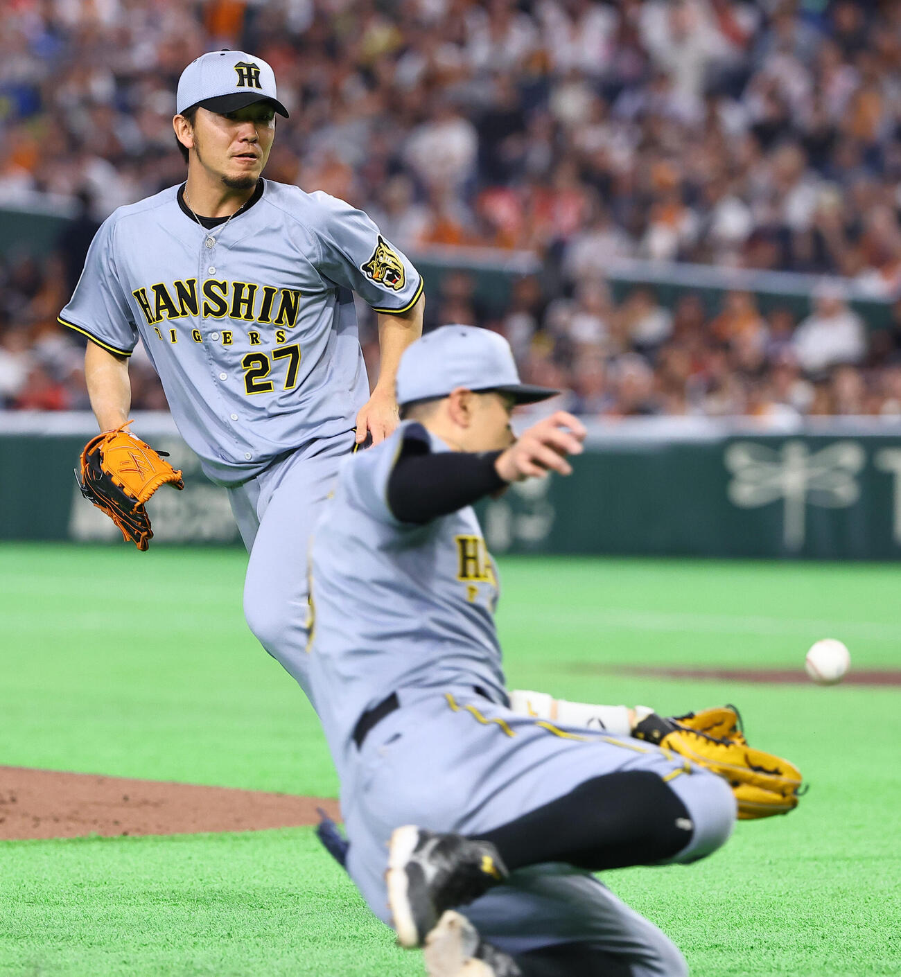 巨人対阪神　1回裏巨人無死一塁、松本のバントを処理する佐藤（手前）を見守る先発の伊藤将（撮影・上田博志）