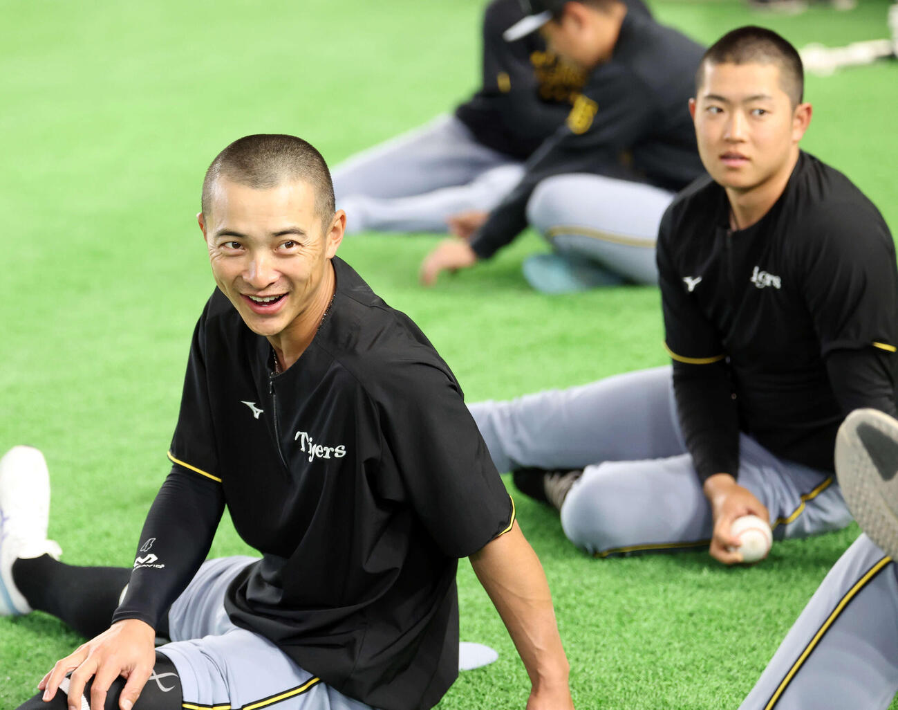 巨人対阪神　丸刈り頭で並んでウオームアップする阪神熊谷（左）と中川（撮影・浅見桂子）